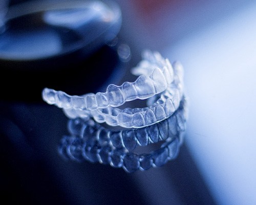 Invisalign aligners on a clear glass surface