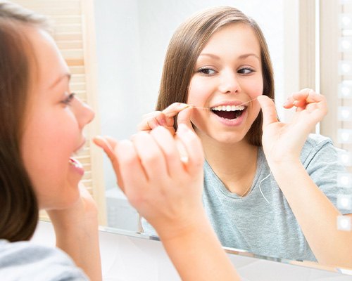 Woman flossing her teeth