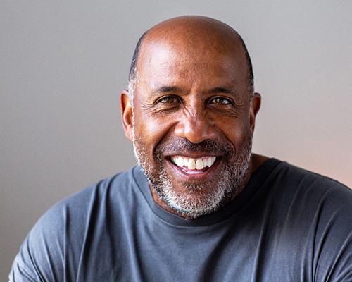Senior man smiling in gray shirt