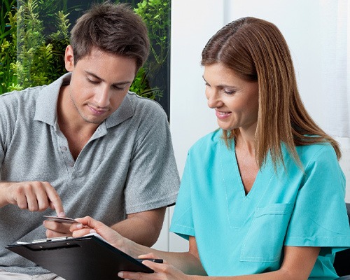 A man using his credit card to pay the cost of Invisalign