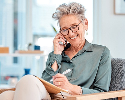 Senior woman smiling while talking on phone at home