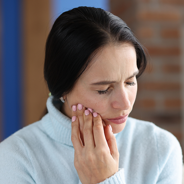 Woman rubbing her jaw in pain