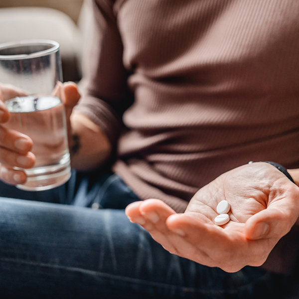 Holding pills and a glass of water