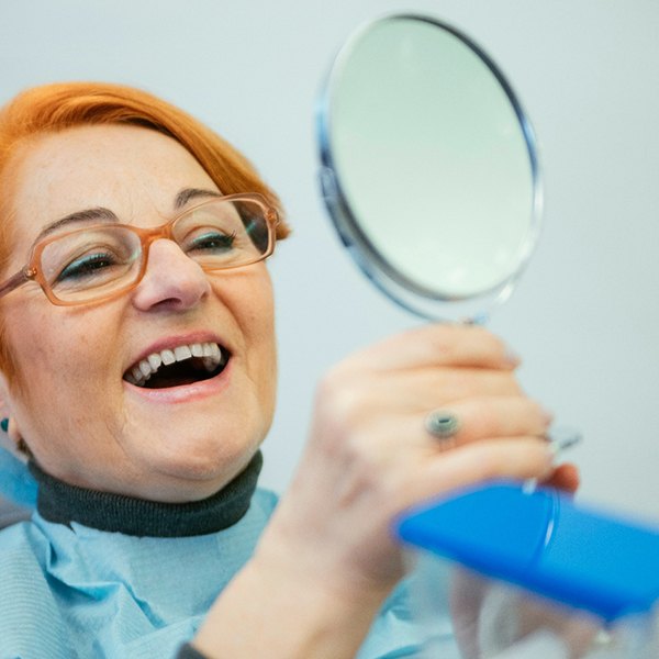 A woman smiling at her new dentures