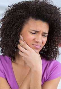 Woman holding jaw with achey tooth