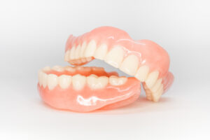 Two full dentures sitting on a white surface