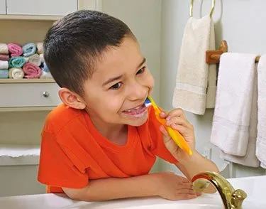 Photo of a smiling child brushing his teeth in Wayne PA
